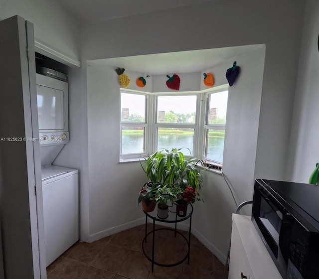 985 NE 34th Ave Unit 203, Homestead, FL 33033 - washroom with stacked washer / drying machine, tile patterned floors, and a water view