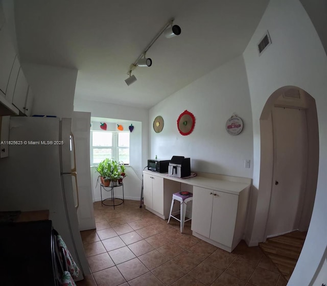 985 NE 34th Ave Unit 203, Homestead, FL 33033 - kitchen with stove, light tile patterned floors, arched walkways, white cabinetry, and an office area
