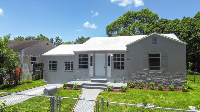 1051 NW 63rd St, Miami, FL 33150 - view of front facade featuring a fenced front yard, stone siding, stucco siding, and a gate