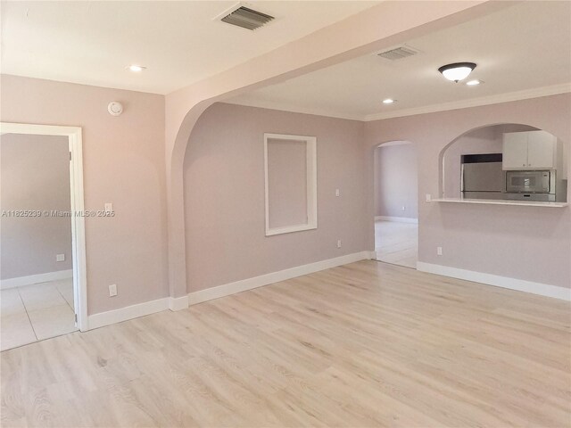 1051 NW 63rd St, Miami, FL 33150 - unfurnished living room with arched walkways, ornamental molding, light wood-type flooring, and recessed lighting