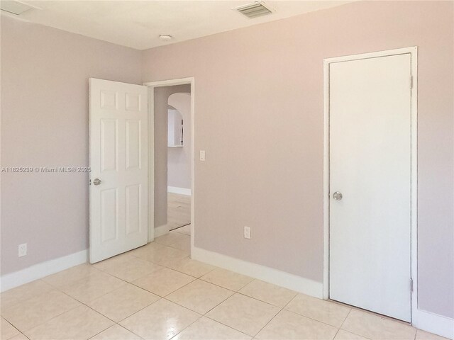 1051 NW 63rd St, Miami, FL 33150 - unfurnished room with arched walkways, light tile patterned floors, and a smoke detector