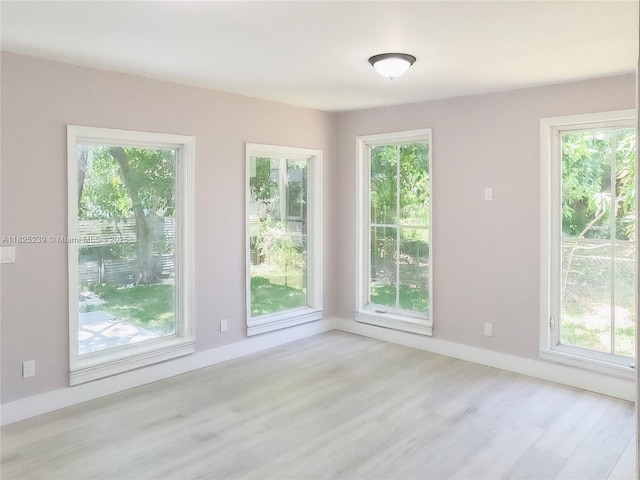 1051 NW 63rd St, Miami, FL 33150 - empty room with light wood-style floors and baseboards