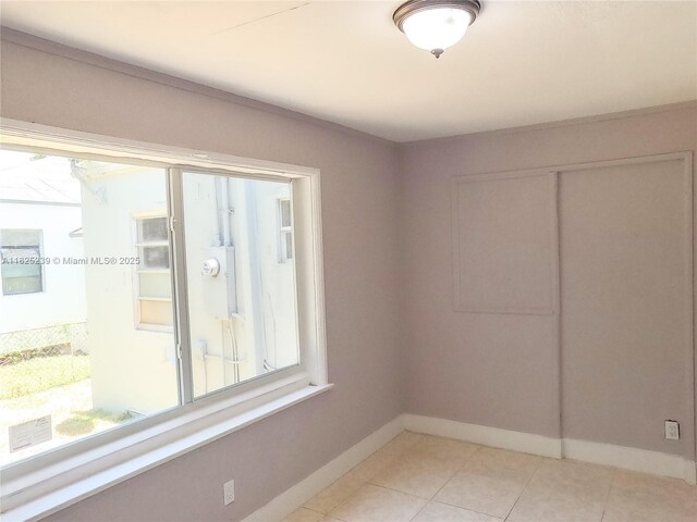 1051 NW 63rd St, Miami, FL 33150 - unfurnished bedroom featuring multiple windows, a closet, and light tile patterned flooring