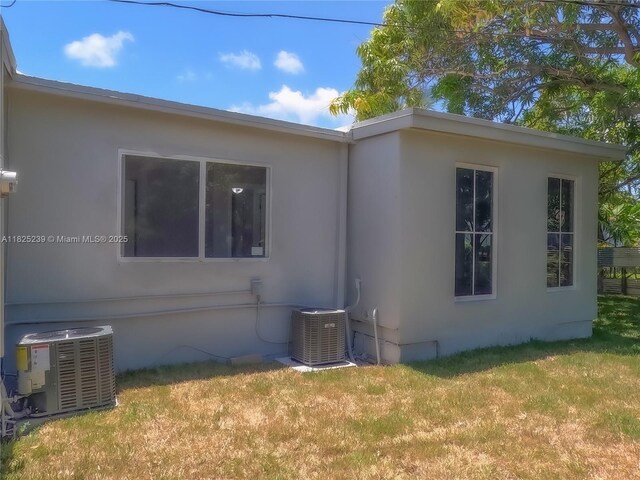 1051 NW 63rd St, Miami, FL 33150 - view of side of home with stucco siding and a lawn
