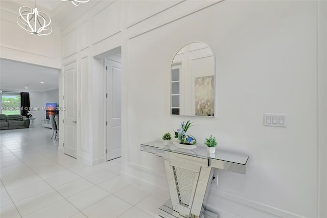 13307 SW Green Delta Rd, Port St Lucie, FL 34987 - hallway featuring light tile patterned floors and a chandelier