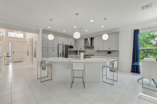 13307 SW Green Delta Rd, Port St Lucie, FL 34987 - kitchen featuring wall chimney range hood, stainless steel appliances, gray cabinets, a breakfast bar, and recessed lighting