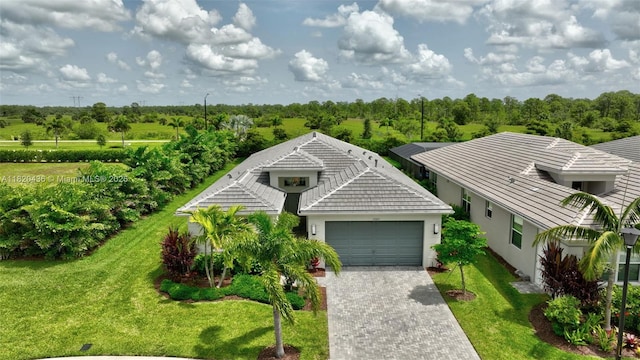 13307 SW Green Delta Rd, Port St Lucie, FL 34987 - view of front of property with a garage, driveway, a front yard, stucco siding, and a tile roof