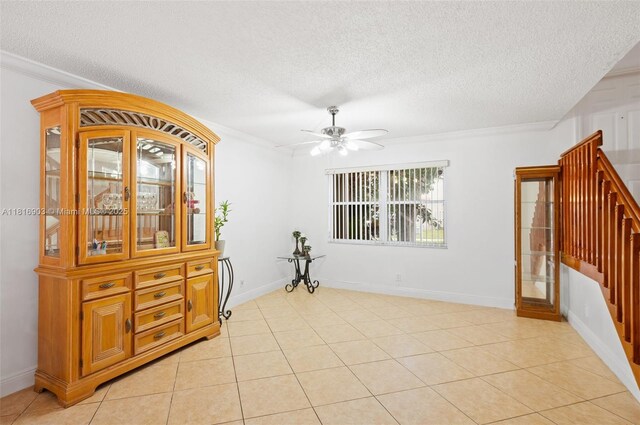 4333 SW 84th Ter, Davie, FL 33328 - spare room with a textured ceiling, ceiling fan, ornamental molding, light tile patterned floors, and stairs