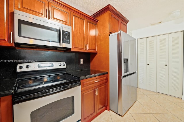 4333 SW 84th Ter, Davie, FL 33328 - kitchen featuring stainless steel appliances, brown cabinets, and light tile patterned flooring
