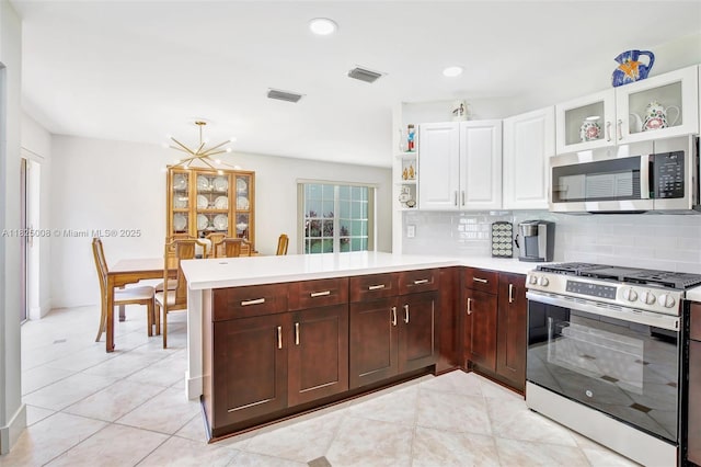 676 NW 133rd Dr, Plantation, FL 33325 - kitchen with appliances with stainless steel finishes, a peninsula, light countertops, backsplash, and light tile patterned flooring