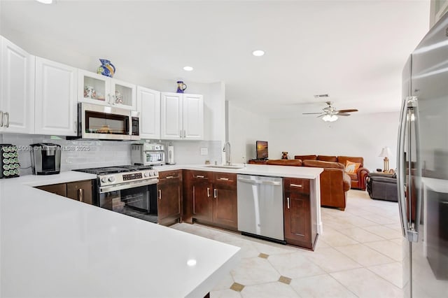 676 NW 133rd Dr, Plantation, FL 33325 - kitchen featuring stainless steel appliances, ceiling fan, light countertops, a peninsula, and decorative backsplash