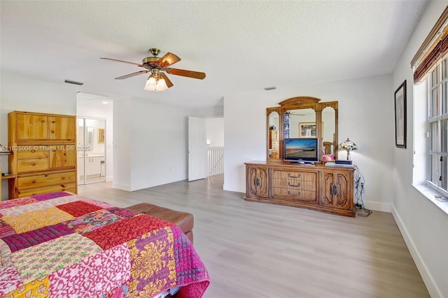 676 NW 133rd Dr, Plantation, FL 33325 - bedroom with wood finished floors, a textured ceiling, a ceiling fan, and connected bathroom