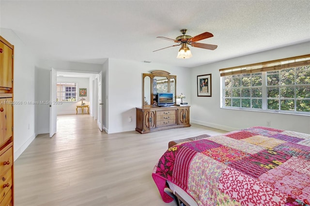 676 NW 133rd Dr, Plantation, FL 33325 - bedroom featuring multiple windows, light wood finished floors, ceiling fan, and a textured ceiling