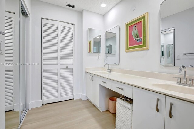 676 NW 133rd Dr, Plantation, FL 33325 - bathroom with a closet, double vanity, wood finished floors, and recessed lighting