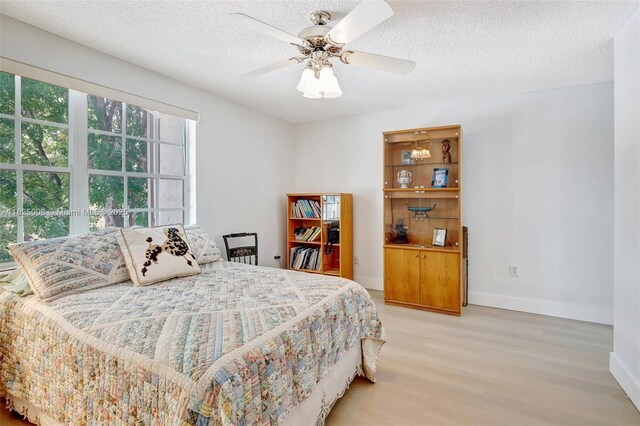 676 NW 133rd Dr, Plantation, FL 33325 - bedroom featuring light wood-style flooring, a textured ceiling, and a ceiling fan