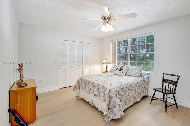 676 NW 133rd Dr, Plantation, FL 33325 - bedroom featuring light wood-style floors, a closet, a textured ceiling, and ceiling fan