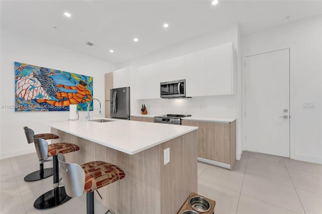 4212 NE 7th Ter, Oakland Park, FL 33334 - kitchen with appliances with stainless steel finishes, a breakfast bar, modern cabinets, light countertops, and white cabinets