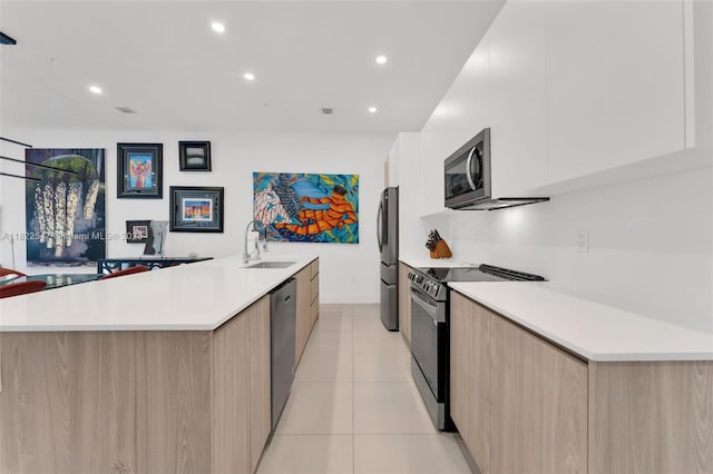 4212 NE 7th Ter, Oakland Park, FL 33334 - kitchen with modern cabinets, appliances with stainless steel finishes, light brown cabinetry, light countertops, and recessed lighting