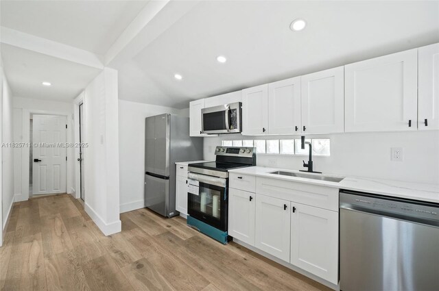 7525 NW 15th Ave, Miami, FL 33147 - kitchen featuring appliances with stainless steel finishes, light wood-style floors, white cabinetry, light stone countertops, and recessed lighting
