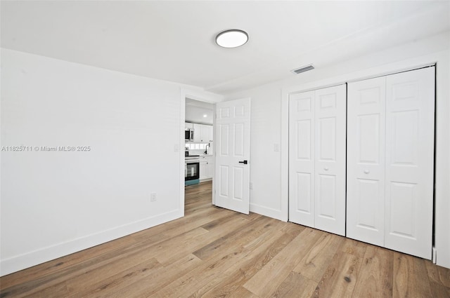 7525 NW 15th Ave, Miami, FL 33147 - unfurnished bedroom featuring light wood finished floors and a closet