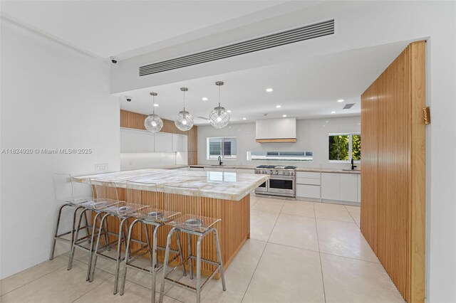 3748 Prairie Ave, Miami Beach, FL 33140 - kitchen with range with two ovens, white cabinets, light countertops, recessed lighting, and light tile patterned floors
