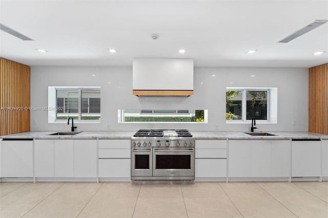 3748 Prairie Ave, Miami Beach, FL 33140 - kitchen featuring double oven range, white cabinets, exhaust hood, light stone countertops, and recessed lighting