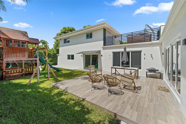 3748 Prairie Ave, Miami Beach, FL 33140 - back of house featuring a playground, a balcony, stucco siding, and a yard