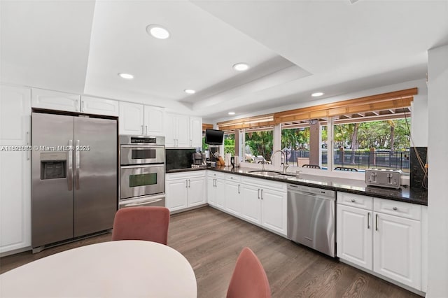 413 Holiday, Hallandale Beach, FL 33009 - kitchen featuring stainless steel appliances, recessed lighting, white cabinets, dark wood finished floors, and a tray ceiling