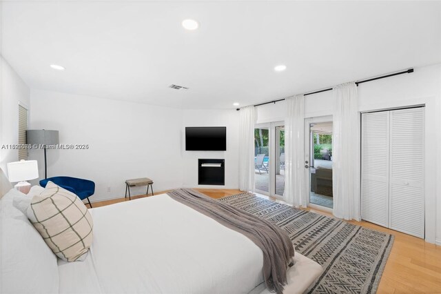 413 Holiday, Hallandale Beach, FL 33009 - bedroom with access to outside, recessed lighting, light wood-style floors, a fireplace, and a closet
