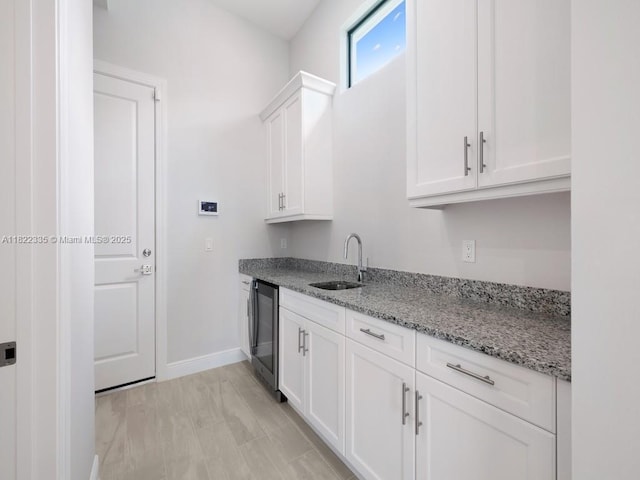 9125 SW Esule Way, Port St Lucie, FL 34987 - kitchen with white cabinetry, light stone countertops, and beverage cooler