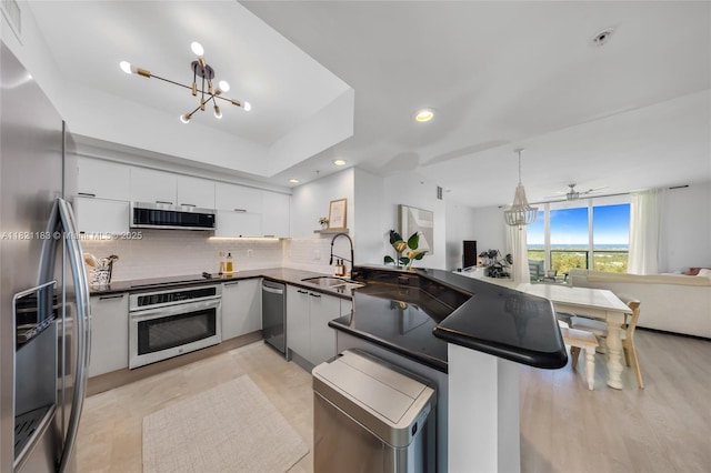 15051 Royal Oaks Ln Unit 1901, North Miami, FL 33181 - kitchen with stainless steel appliances, a chandelier, dark countertops, tasteful backsplash, and white cabinetry
