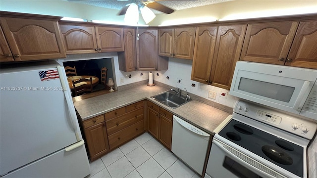 7680 NW 1st St Unit 107, Margate, FL 33063 - kitchen with white appliances, ceiling fan, light tile patterned floors, brown cabinetry, and decorative backsplash