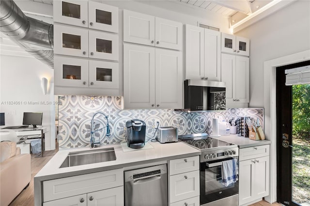 1301 Milan Ave Unit 5, Coral Gables, FL 33134 - kitchen featuring appliances with stainless steel finishes, decorative backsplash, light countertops, and beam ceiling