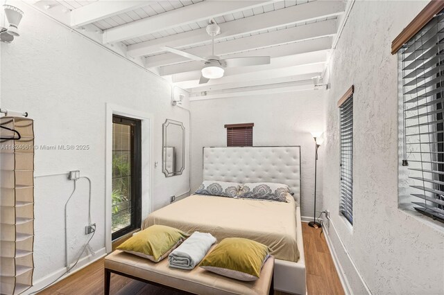 1301 Milan Ave Unit 5, Coral Gables, FL 33134 - bedroom featuring beamed ceiling, wood finished floors, a textured wall, and a ceiling fan