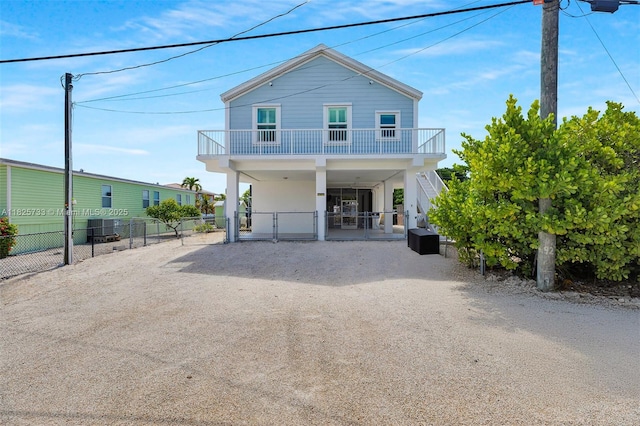 103 Long Key Rd, Key Largo, FL 33037 - rear view of property featuring a carport, a gate, dirt driveway, stairway, and a balcony