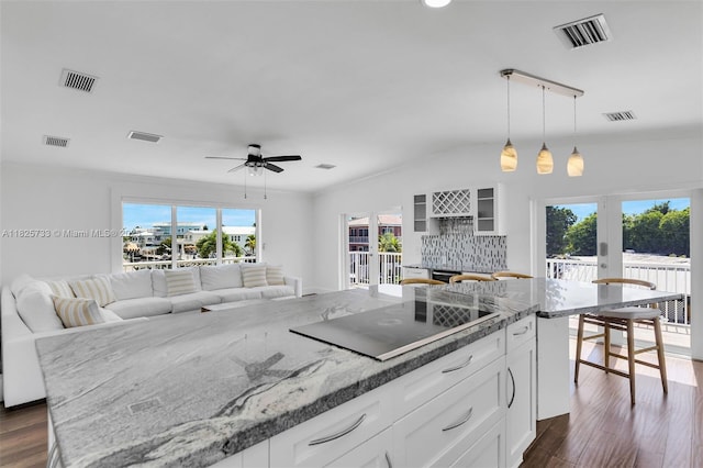 103 Long Key Rd, Key Largo, FL 33037 - kitchen with black electric stovetop, white cabinetry, dark wood-type flooring, decorative backsplash, and lofted ceiling