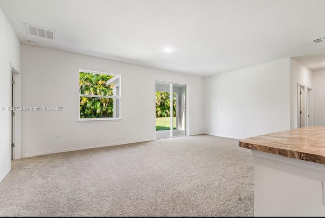 485 SW Molloy St, Port St Lucie, FL 34984 - unfurnished living room featuring carpet flooring and baseboards