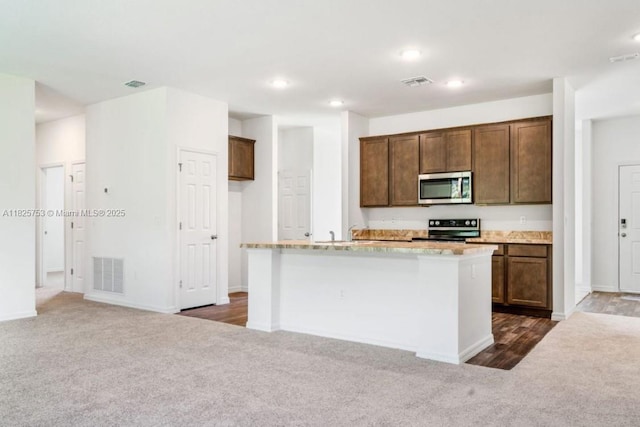485 SW Molloy St, Port St Lucie, FL 34984 - kitchen featuring stainless steel microwave, electric range, dark colored carpet, recessed lighting, and a center island with sink