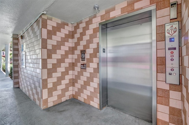 13155 SW 7th Ct Unit 308E, Pembroke Pines, FL 33027 - bathroom with elevator, a textured ceiling, and concrete flooring