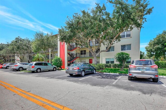 13155 SW 7th Ct Unit 308E, Pembroke Pines, FL 33027 - view of building exterior featuring uncovered parking