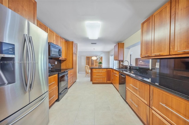10220 SW 108th St, Miami, FL 33176 - kitchen with black appliances, brown cabinets, dark stone counters, and a peninsula