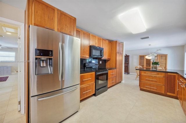 10220 SW 108th St, Miami, FL 33176 - kitchen with black appliances, brown cabinets, dark countertops, light tile patterned floors, and hanging light fixtures