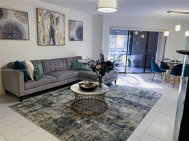 6555 W Broward Blvd Unit 208, Plantation, FL 33317 - living area featuring marble finish floors and a textured ceiling