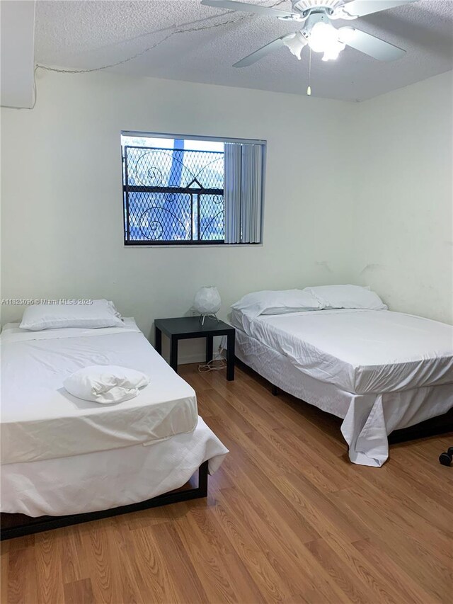 6555 W Broward Blvd Unit 208, Plantation, FL 33317 - bedroom featuring wood finished floors, a ceiling fan, and a textured ceiling