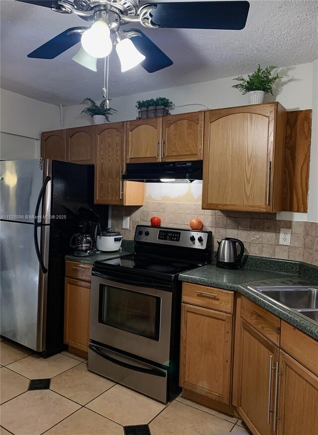 6555 W Broward Blvd Unit 208, Plantation, FL 33317 - kitchen featuring appliances with stainless steel finishes, under cabinet range hood, dark countertops, decorative backsplash, and light tile patterned floors
