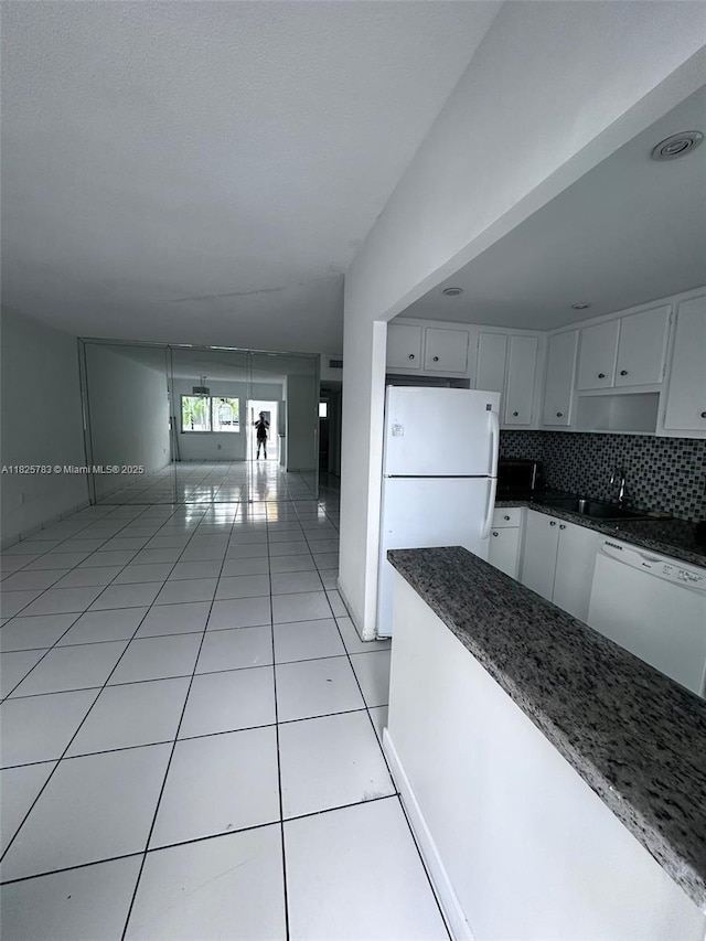 2430 NE 135th St Unit 304, North Miami, FL 33181 - kitchen with white appliances, light tile patterned flooring, white cabinetry, and dark stone counters