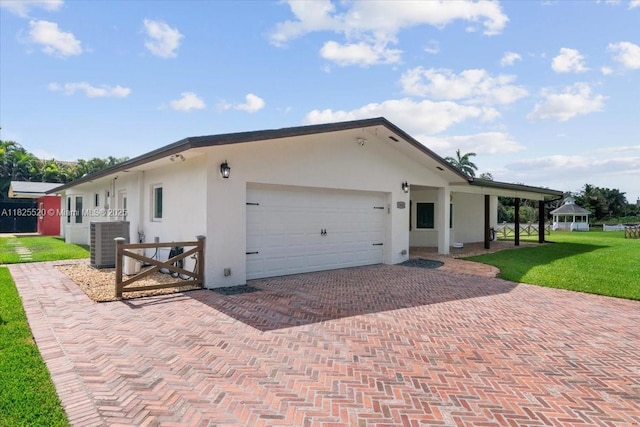 1550 NW 114th Ave, Plantation, FL 33323 - view of front of home featuring stucco siding, a garage, decorative driveway, a front yard, and a gazebo