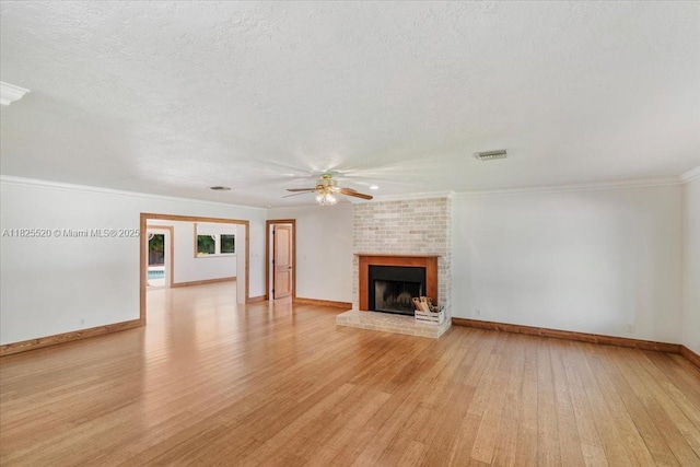 1550 NW 114th Ave, Plantation, FL 33323 - unfurnished living room with ceiling fan, light wood-style floors, a brick fireplace, crown molding, and a textured ceiling