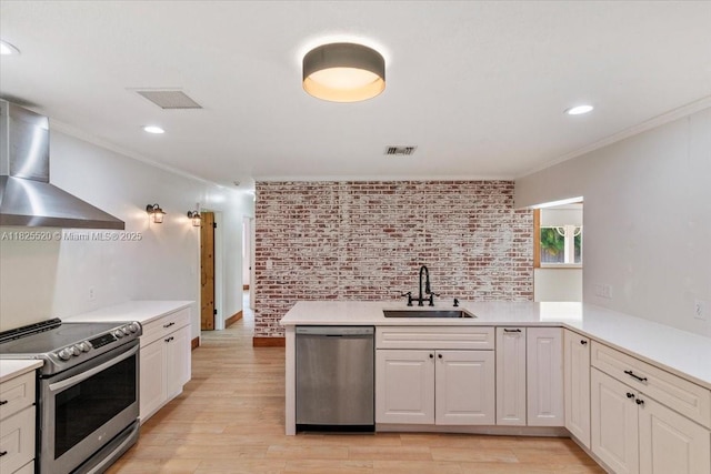1550 NW 114th Ave, Plantation, FL 33323 - kitchen featuring appliances with stainless steel finishes, wall chimney range hood, crown molding, light countertops, and light wood-type flooring