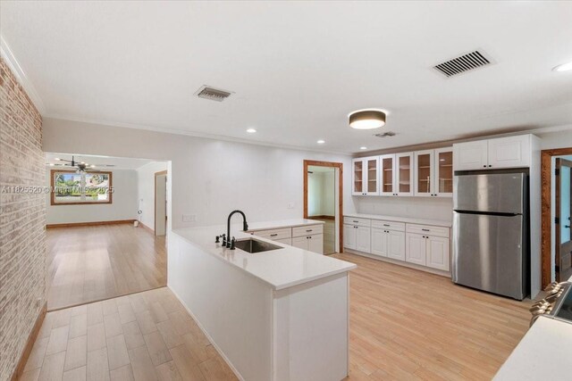 1550 NW 114th Ave, Plantation, FL 33323 - kitchen featuring freestanding refrigerator, glass insert cabinets, a peninsula, light wood-style flooring, and light countertops